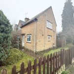 Stone house with wooden fence and garden