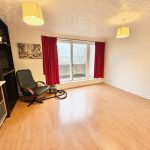 Bright empty room with wooden floor and red curtains.