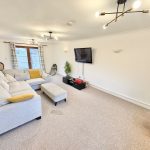 Spacious lounge with modern decor and large sofa.