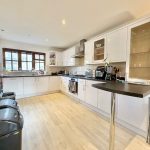 Modern kitchen with white cabinets and appliances.