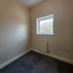 Small room with window, carpet, and radiator