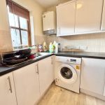 Modern kitchen with washing machine and countertop.
