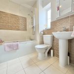 Modern bathroom with bathtub, sink, and toilet.