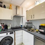 Compact kitchen with appliances and countertop essentials.