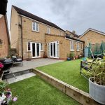 Modern brick house with garden and patio area.