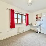 Bright room with red curtains and desk.
