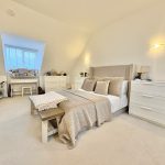 Cosy bedroom with modern beige decor and furniture.