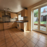 Spacious kitchen with garden view and wooden cabinets.