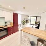 Modern kitchen and living room with wooden furnishings.
