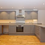 Modern kitchen with grey cabinets and wooden floor