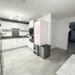 Modern kitchen with white cabinets and appliances.