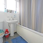Modern bathroom with shower curtain and toilet.