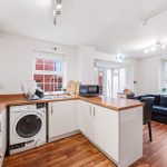 Modern kitchen and cosy living area in flat.