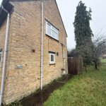 Stone house with garden, large tree.