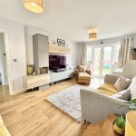 Modern living room with comfortable seating and garden view.