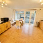 Spacious kitchen with wooden cabinets and dining area.