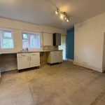Spacious kitchen interior with white cabinets and large windows.