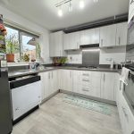 Modern kitchen with light cabinets and grey countertop.