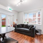 Modern living room with grey sofa and wooden floor.