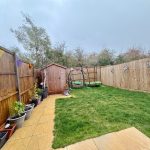 Back garden with shed and green bin