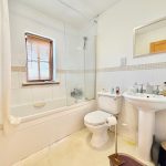 Modern bathroom with bath, shower, sink, and toilet.