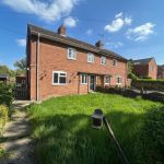 Red-brick house with garden on a sunny day.