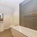 Modern bathroom with bathtub and vanity unit.