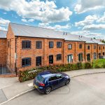 Row of modern brick terraced houses, blue sky.