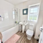 Modern bathroom with bath, sink, and toilet.