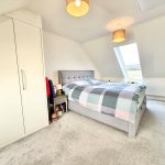 Bright bedroom with skylight and grey furniture