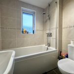 Modern bathroom with tub, shower, and toilet.