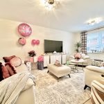 Living room decorated for celebration with balloons and gifts.