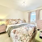 Cosy bedroom with floral bedding and elegant decor.