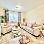 Cosy living room with beige sofas and pink decor.