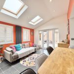 Bright modern living room with skylights and colourful decor.