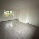 Unfurnished room with wooden floor and window view.