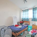 Messy bedroom with toys and clothes scattered around.