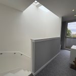 Bright stairway leading to balcony with scenic view.