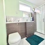 Modern bathroom with shower and wooden cabinets.