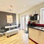 Modern kitchen dining area with wooden floor.