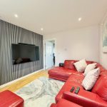 Modern living room with red sofa and TV.