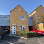 Modern brick house with parked cars in driveway.