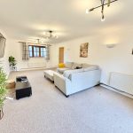Spacious living room with modern decor and lighting.