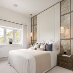 Modern bedroom with elegant decor and large window.