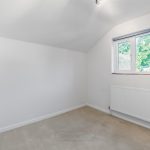Small empty room with window and radiator.