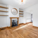 Bright room with wooden fireplace and floor.