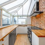 Modern kitchen with brick wall and skylight windows.
