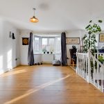 Bright room with wooden floor and bay window.