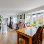 Bright dining room with wooden floors and large windows.