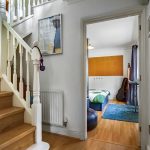 Staircase leading to bedroom with guitar case.